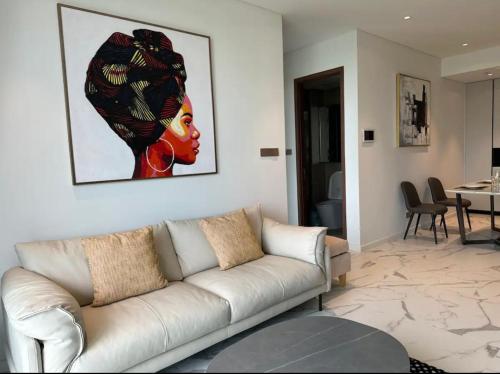 a living room with a couch and a painting on the wall at THE METROPOLE Apartment Complex OPERA-GALLERIA-CREST in Ho Chi Minh City