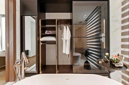 a bathroom with a tub and a toilet and a sink at THE METROPOLE Apartment Complex OPERA-GALLERIA-CREST in Ho Chi Minh City
