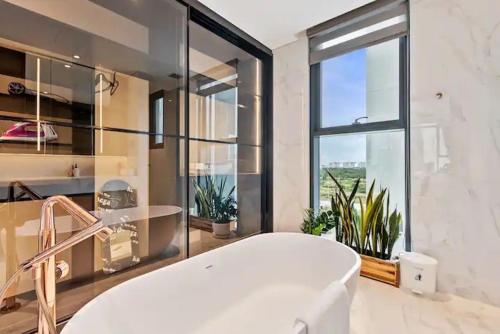 a bath tub in a bathroom with a large window at THE METROPOLE Apartment Complex OPERA-GALLERIA-CREST in Ho Chi Minh City