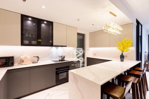 a kitchen with a white counter top and some chairs at THE METROPOLE Apartment Complex OPERA-GALLERIA-CREST in Ho Chi Minh City