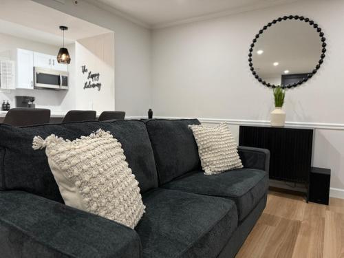 a living room with a black couch and a mirror at Newly Renovated Villa with King Bed and Amenities, 1 mile to Mohegan Sun in Norwich