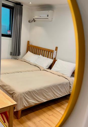 two beds in a room with a mirror at Studio 6 in Seoul