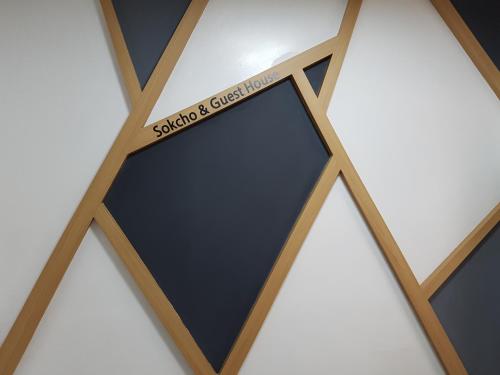 a wooden frame with a black rectangle with a sign on it at Sokcho & Guesthouse in Sokcho