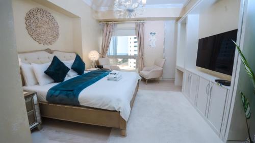 a bedroom with a large bed and a television at ROYAL BEACH RESIDENCES 2 in Dubai