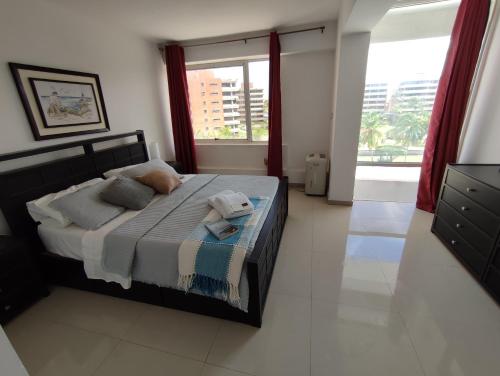 Un dormitorio con una cama y una ventana grande en JB Beach apartment, en El Morro de Barcelona