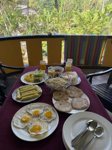 a table with plates of breakfast food on it at freedom house in Unawatuna