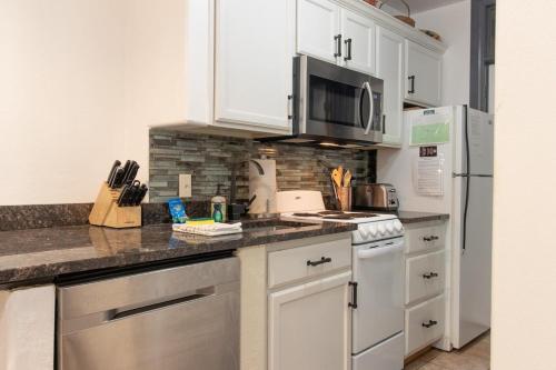 a kitchen with white cabinets and stainless steel appliances at 7 Guests 2BR 2BA Pool Hot Tub & Game Room at CBL in Brian Head