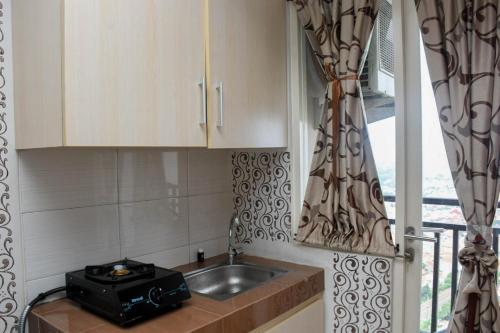 デポックにあるComfy and Tidy Studio Apartment at Margonda Residence 4 near UI By Travelioの小さなキッチン(シンク付)、窓