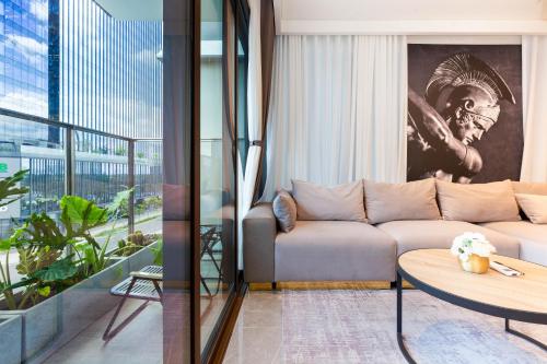 a living room with a couch and a table at THE METROPOLE Apartment Complex OPERA-GALLERIA-CREST in Ho Chi Minh City