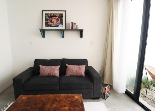 a black couch in a living room with a table at Aviva Hotel in Tzununá