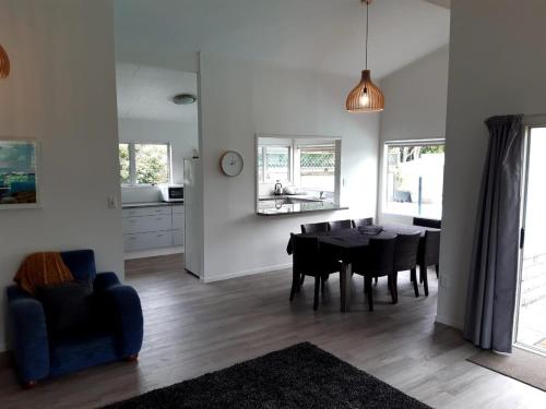a dining room and living room with a table and chairs at Sunny Family Haven with Pool in Napier