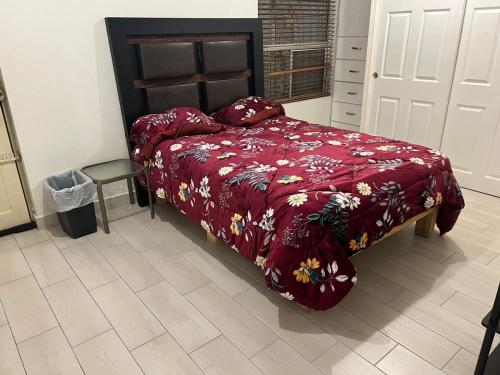 a bedroom with a bed with a red comforter at Soñar in Manuel F. Martínez