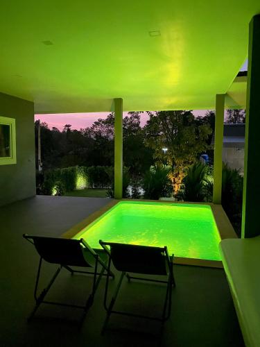 a swimming pool in a house with two chairs at Hornbill Pool Villas 1 in Ko Chang