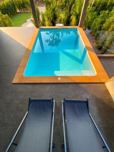 a swimming pool with two chairs in a backyard at Hornbill Pool Villas 1 in Ko Chang