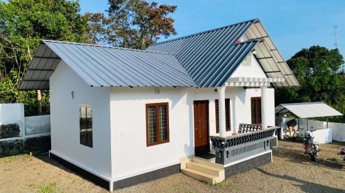 a small white house with a metal roof at Vagamon Hill On Misty Private villa2BHK in Vagamon