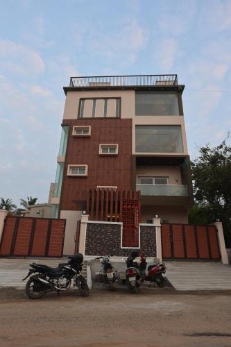 two motorcycles parked in front of a building at MM Beach House & Party Hall in Chennai