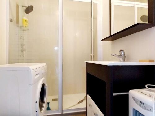 une salle de bain avec une machine à laver et un lavabo dans l'établissement Studio confortable avec WiFi, parfait pour 2 personnes - FR-1-553-297, à Balaruc-les-Bains