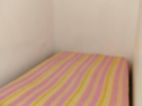 - un lit rayé dans un coin de chambre dans l'établissement Studio cabine climatisé avec piscine et parking à Bormes-les-Mimosas - FR-1-610-105, à Bormes-les-Mimosas