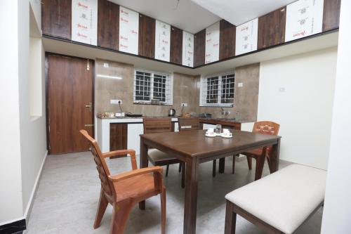 a dining room with a wooden table and chairs at MM Beach House & Party Hall in Chennai
