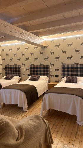 a bedroom with two beds with bats on the wall at Casa de montaña d'Ordino HUT 8268 in Ordino