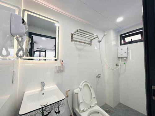 a white bathroom with a toilet and a sink at Rainbow Beach Mũi Né - Homestay & Coffee in Ấp Khánh Phước (1)