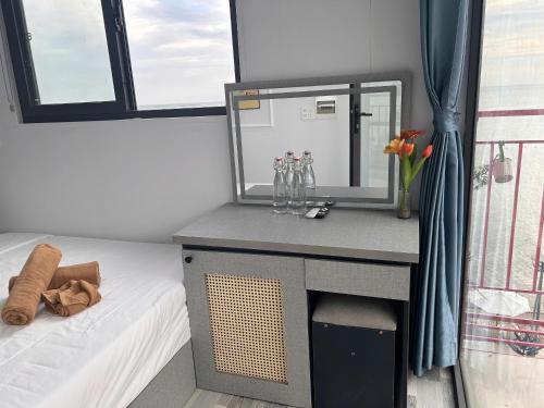 a bedroom with a desk and a bed with a mirror at Rainbow Beach Mũi Né - Homestay & Coffee in Ấp Khánh Phước (1)