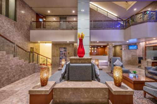 a lobby with a couch and a red vase at Lords Plaza Jaipur in Jaipur