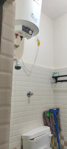 a bathroom with a toilet with a light above it at "Ambi's stay " A unique and Secluded Nest with serene calmness views on a Traffic-Free Street at Bommasandra 3 km from Narayana Hrudayalaya Hospital in Bangalore