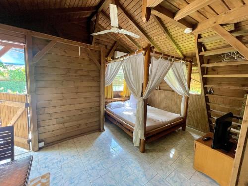 a bedroom with a bed in a wooden room at Lodge Indigo in Le Gosier