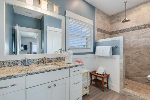 a bathroom with a sink and a large mirror at Cape Ocean Front - Jacuzzi - Elevator - Arcade Games! in Port Saint Joe