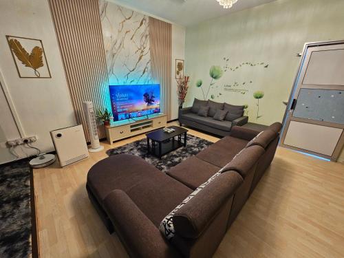 a living room with a couch and a flat screen tv at Arlyn's Homestay in Sandakan