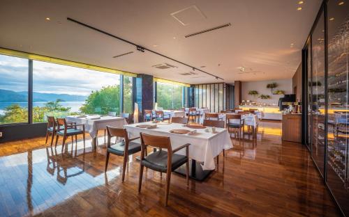 a restaurant with tables and chairs and large windows at Hotel Premium Lake TOYA in Lake Toya