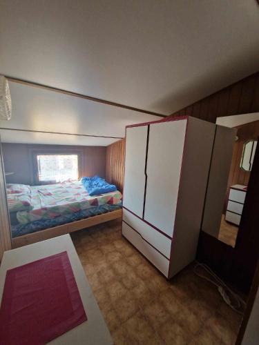 - une petite chambre avec un lit et un placard dans l'établissement Maison avec piscine chauffée de Pâques à la toussaint accès animation & parc aquatique de juin à fin septembre, à Portiragnes