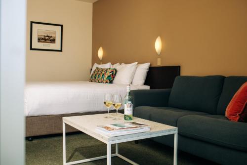 a hotel room with a bed and a table with wine glasses at Port Lincoln Hotel in Port Lincoln