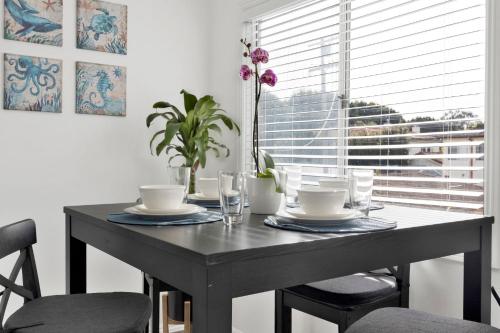 a dining room table with chairs and a table with dishes at Cozy, Luxurious, Oasis, With Free parking in Los Angeles