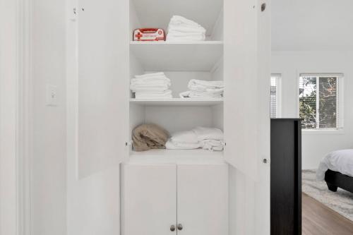 a white closet with white cabinets and towels at Cozy, Luxurious, Oasis, With Free parking in Los Angeles