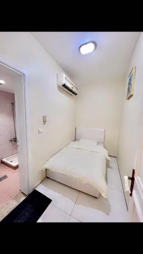 a white room with a bed and a bathroom at درة العروس لونق بيش مسبح in Durat  Alarous