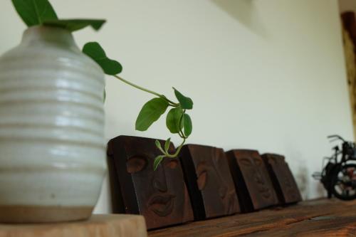 a plant in a vase sitting on top of a table at Ming Shui Lu Homestay in Xingjian