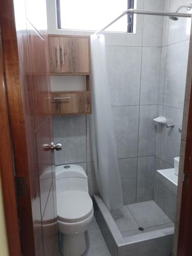 a small bathroom with a toilet and a shower at Habich Apartment in Lima