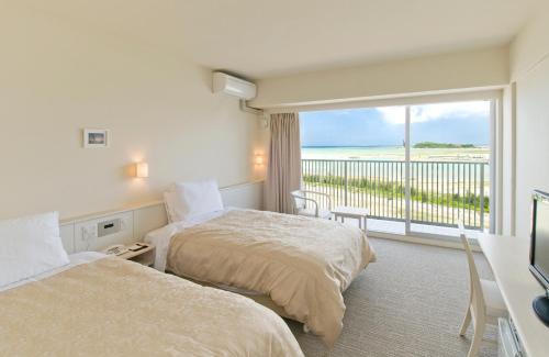 a hotel room with two beds and a balcony at Hotel Gran View Garden Okinawa in Tomigusuku