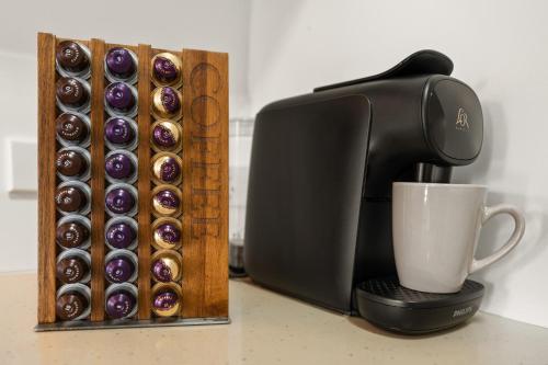 a coffee maker with a cup and a box of donuts at Cairns Penthouse - Private Rooftop Outdoor Gym, Spa & TV Area with Sunset & Mountain Views in Cairns