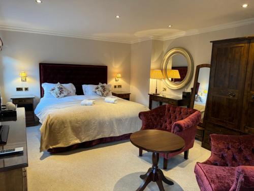 a bedroom with a bed and a table and a chair at Wellwood Manor in Pitlochry