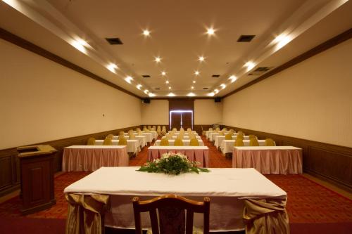a banquet hall with tables and chairs in it at Rimpao Hotel in Kalasin