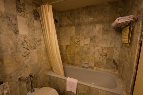 uma casa de banho com uma banheira, um WC e um lavatório. em Rimpao Hotel em Kalasin