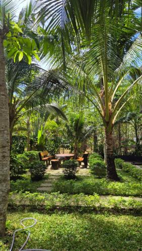 a park with picnic tables and palm trees at Valentina Resort & Spa Phu Quoc in Phu Quoc