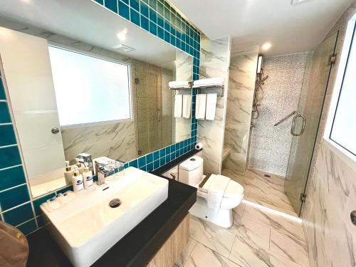 a bathroom with a sink and a toilet and a mirror at D Eco Wellness Center in North Pattaya