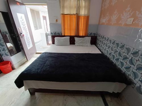 a bedroom with a large bed in a room at Hotel O Home Shri Hari Lodge Homestay in Ayodhya
