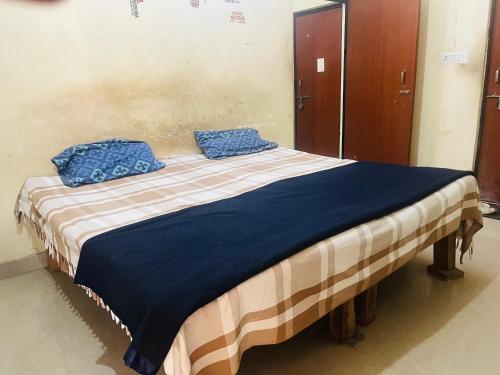 a bed with two blue pillows on top of it at Yadav multi in Prayagraj