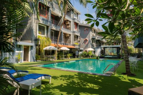 a swimming pool in front of a building at Magnum Resorts Candolim in Candolim