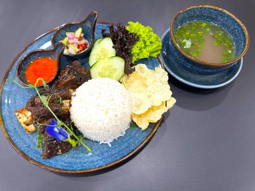 a plate of food with rice and a bowl of soup at Howard Johnson By Wyndham Tangerang in Tangerang